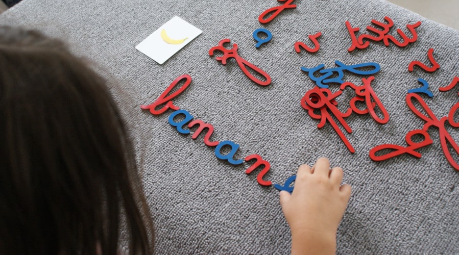 enfant qui utilise un alphabet Mobile Montessori